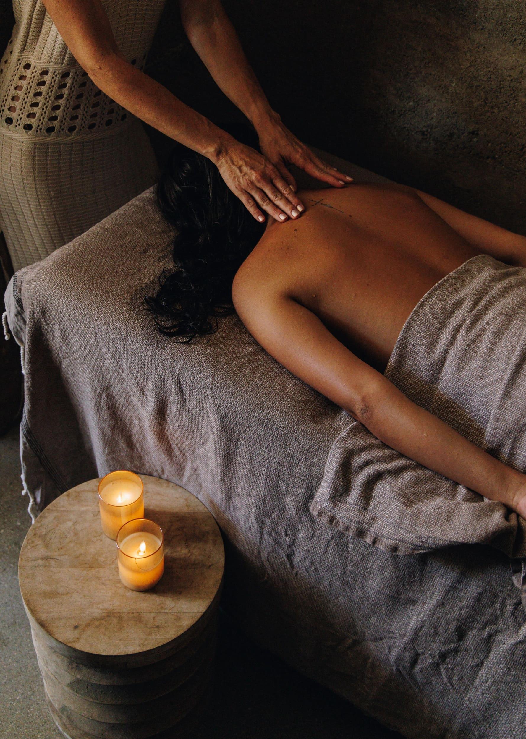 Professional massage therapy session with candles lit during a spa treatment